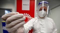 Un sanitario del aeropuerto de Dusseldorf recoge una muestra para comprobar si el virus tiene la cepa britnica