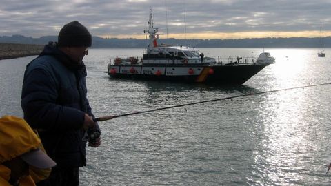 Una patrullera de la Guardia Civil navega frente a pescadores recreativos, aficionados que cuando se apruebe la Ley de Pesca Sostenible debern cumplir nuevas obligaciones cuando lancen las caas en aguas exteriores (foto de archivo)