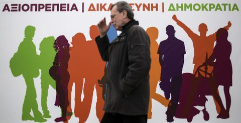 Un hombre camina en Atenas ante un cartel electoral de Syriza, formacin a la que los sondeos atribuyen la victoria. 