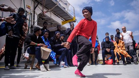 Una nia baila junto a un grupo de migrantes rescatados en aguas del Mediterrneo