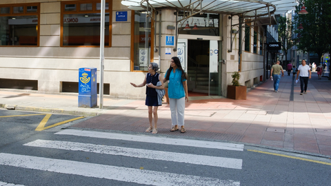 Inés cruza la calle junto a Alba, experta de la Unidad de Rehabilitación de Daño Cerebral del Hospital Quirónsalud en Pontevedra.