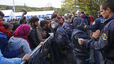 Un grupo de refugiados tratan de romper un cordn policial en  Sentilj, en la frontera de Eslovenia con Austria
