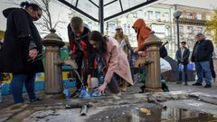 Vecinos de Kiev rellenan botellas y garrafas de agua en fuentes pblicas tras el bombardeo ruso en la ciudad.