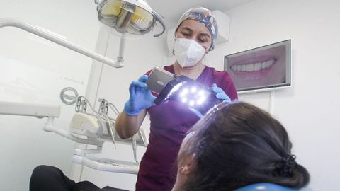 La odontóloga Patricia Aneiros, realizando un estudio de la sonrisa a una clienta en su clínica de Ferrol