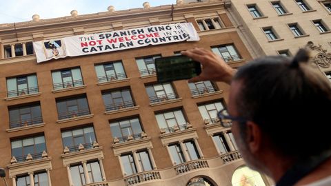 Un grupo de independentistas ha colgado una pancarta en contra del rey en la fachada de un edificio de la plaza de Cataluña de Barcelona, donde se va a celebrar el acto central en recuerdo de las víctimas de los atentados del 17A. 