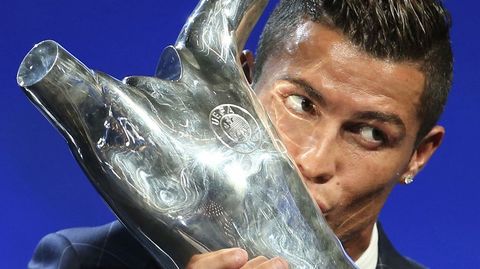 El futbolista del Real Madrid, Cristiano Ronaldo, besa el premio de la UEFA al Mejor Jugador 2015/16 durante el sorteo de la Champions