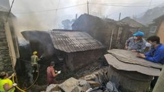 Bomberos y voluntarios trabajaron ayer en Vilar intentando contener el impacto de las llamas en las viviendas. 