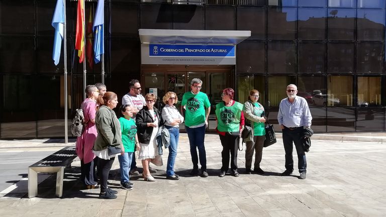 Los protestantes junto con la familia delante de la Consejería de Servicios y Derechos Sociales