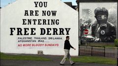 Un hombre pasa frente a uno de los murales de la zona catlica de Derry