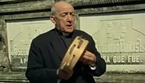 Saturnino Cuíñas, cura de Cesullas-Cabana, toca la pandetera en el programa «Raíce»s de TVE en 1973, al lado de la lápida de su futuro nicho y que ya lleva su nombre