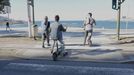 Dos patinetes cruzan un paso de peatones en el paseo marítimo de A Coruña