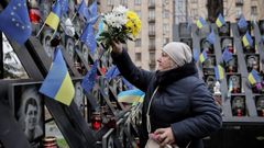 Una mujer deposita flores en el memorial del Maidán, en Kiev.