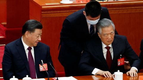 Siguiendo las indicaciones de Xi Jinping, el bedel del Gran Palacio le comunica a Hu Jintao que debe abandonar la sala