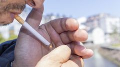 Un fumador se enciende un cigarrillo en Carballo