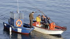 Mariscadores a flote extrayendo almeja en As Pas