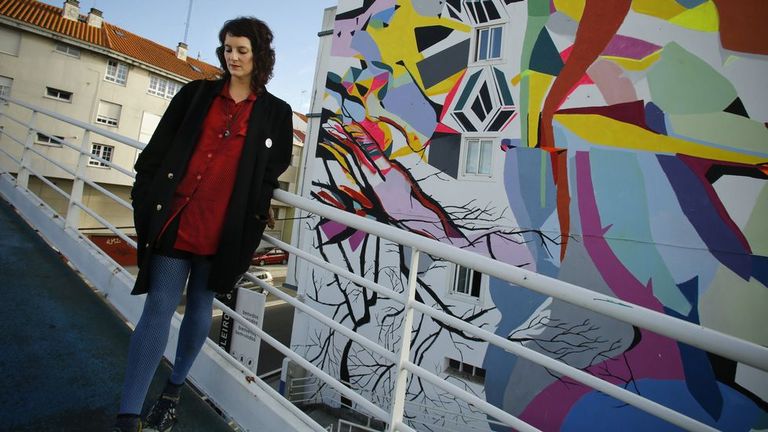 Paula Fraile, junto al mural que realizó en una vivienda próxima al punte de A Pasaxe