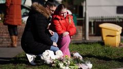 Una mujer y su hija depositan flores cerca del lugar donde fue hallado sin vida el beb en Brighton.