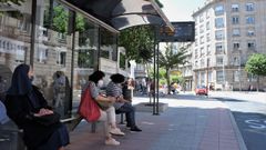 Usuarios esperando por el bus en una parada de Ourense.
