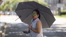 Una mujer se protege del sol con un paraguas en plena ola de calor