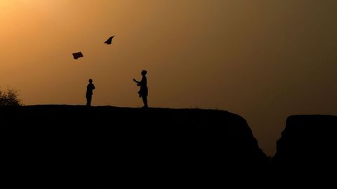 Dos nios afganos juegan con sus cometas