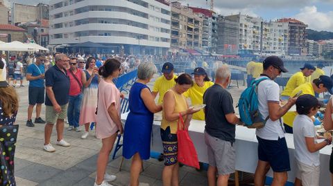 Público recogiendo su ración en la sardiñada de las fiestas de Sanxenxo
