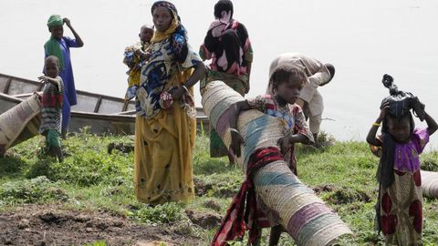 Mujeres llevando alfombras y otras pertenencias en Chad, frica Central