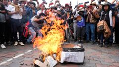Varios manifestantes fotografan en Cusco la quema de un atad simulado de Dina Boluarte, la nueva presidenta de Per.
