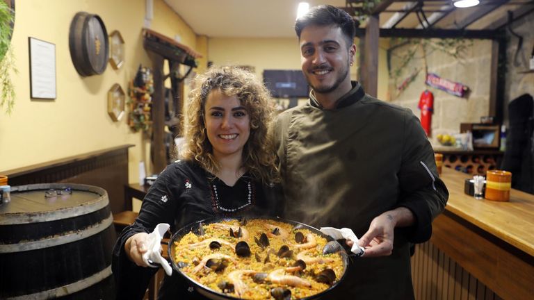 María y Julio posan con una de las paellas de marisco que hacen en O escalón do meco