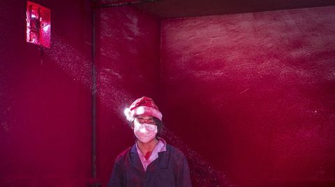 We, un trabajador chino de 19 aos de edad, con un sombrero de Papa Noel y una mscara en una fbrica donde se crean adornos navideos.