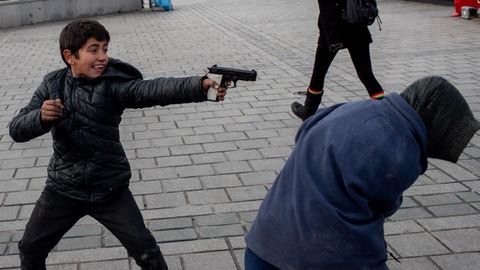 Nios refugiados sirios se divierten con una pistola de juguete en Estambul, Tuqua