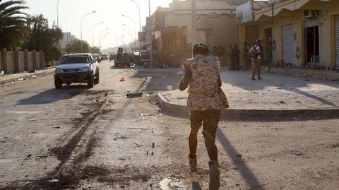 Miembros de las fuerzas leales al gobierno libio amparado por las Naciones Unidas corre por una calle en el centro, donde luchan contra un grupo del Estado Islmico.