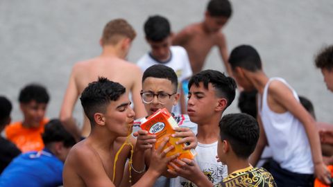Ciudadanos marroquíes beben zumo tras cruzar la frontera