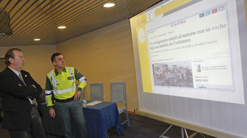 El fiscal Carlos Gil y el teniente coronel Molano ayer en Santiago durante una reunión de trabajo consultando una noticia de un accidente