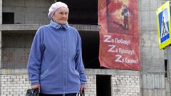 Una mujer camina por una calle de Mosc frente a un cartel en apoyo de la invasin rusa de Ucrania