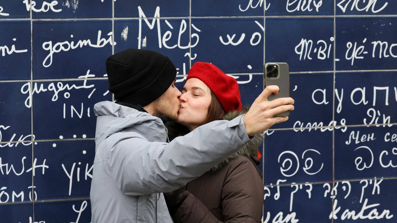 Una pareja se toma un selfie mientras se besa delante del Muro del Amor en la plaza del jardn Jehan Rictus, en Pars, Francia.