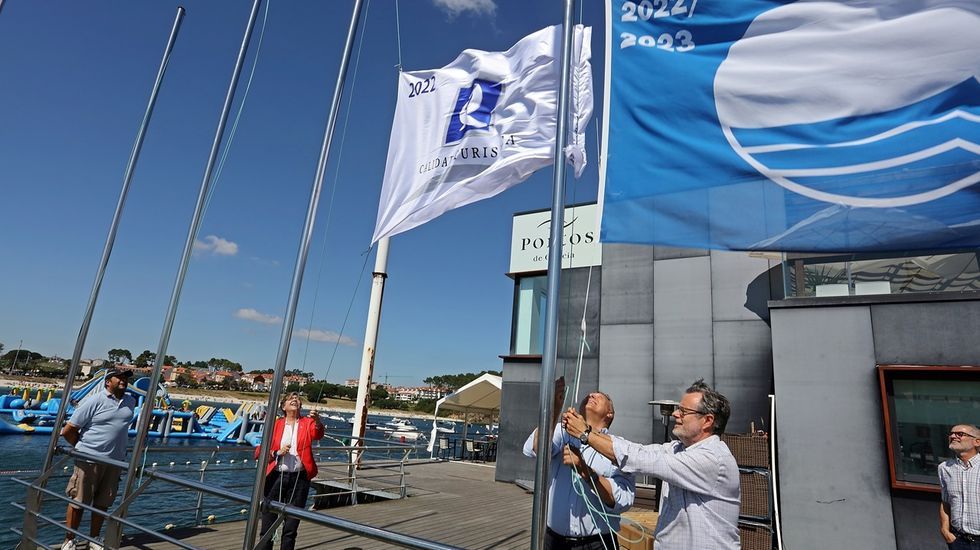 Las imgenes de la primera noche del Albario.Rosa Quintana iza la Q de Calidad y el presidente del Nutico de Portonovo la bandera azul en el muelle de O Chasco