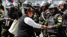 Una mujer entrega propaganda a las fuerzas de seguridad desplegadas en La Paz