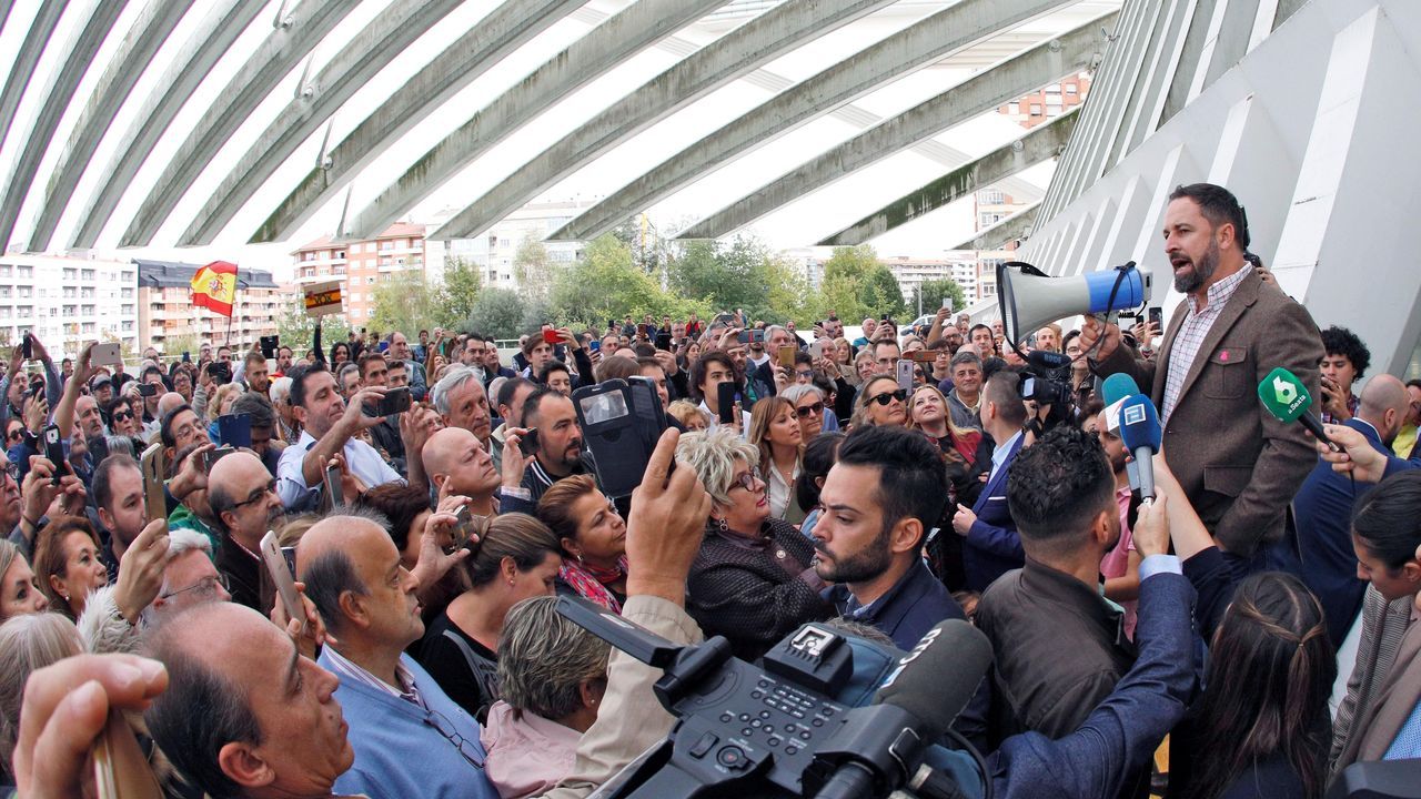 El líder de Vox, Santiago Abascal (d) se dirige con un megáfono a un grupo de simpatizantes