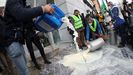 Un grupo de los ganaderos que acudieron esta mañana a Madrid tiran leche ante la sede de la multinacional Lactalis