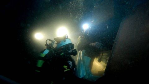 Fotografa facilitada por los carabineros italianos, que muestra a varios buzos inspeccionando el interior del Costa Concordia.