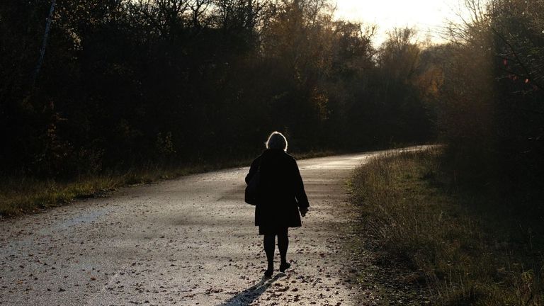 Una mujer camina por una carretera