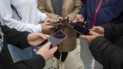 Un grupo de adolescentes con sus móviles delante del instituto Alfredo Brañas de Carballo