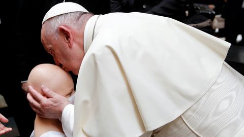 El papa Francisco besa a una niña después de una oración ecuménica 