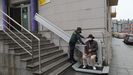 Un agente ayuda a un usuario a utilizar la nueva escalera en el puesto de Cambre