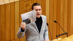 El diputado del PSdeG-PSOE en el Parlamento de Galicia, Aitor Bouza, mostrando una foto de la situaci&oacute;n de las viviendas.