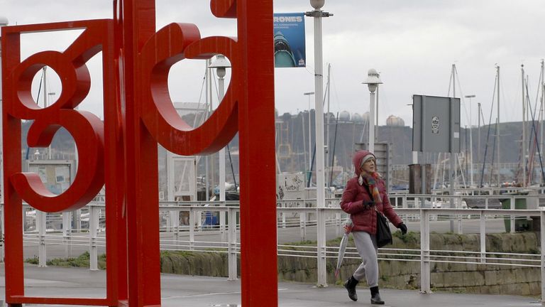 Una mujer camina por el puerto deportivo de Gijón