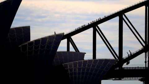 Varios turistas cruzan a través de la estructura superior el puente Harbour Bridge en Sidney.