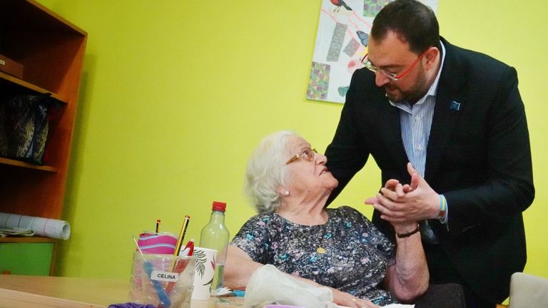 El secretario general de la FSA-PSOE, presidente del Principado y candidato, Adrián Barbón, junto a una usuaria del centro de día de Luarca
