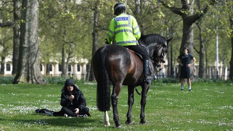 Un polica a caballo conversa con una persona en el parque St James de Londres. 