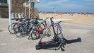 Patinetes eléctricos de uso compartido, aparcados en la playa de Poniente